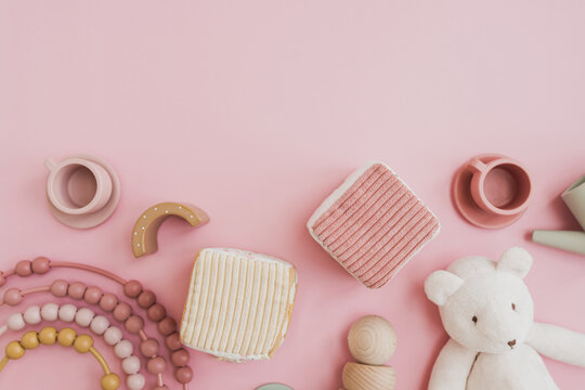 Baby Kids Toys Background. Teddy Bear, Wooden Educational Stacking Rainbow, Toy Kitchenware On Pastel Pink Background. Top View, Flat Lay Mock Up With Blank Empty Copy Space