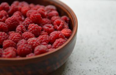 Red fresh raspberries in a bowl