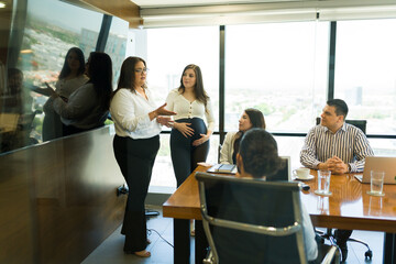 Businesswoman giving presentation to team in conference room