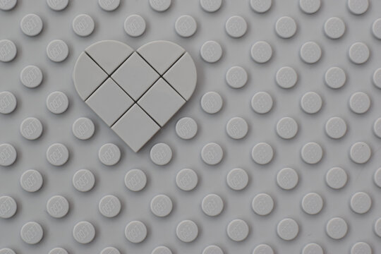 Lego gray baseplate with heart shape on round knots to assembly plastic bricks from popular toy brand. Editorial illustrative image of popular children plastic toy.