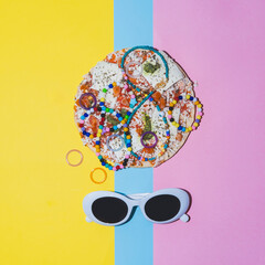 Beads and necklaces on pizza in a minimalist style near the white sunglasses. Creative concept of fashionable food.