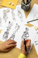 An artist draws characters for computer games. Illustrator drawing sketches on paper. Animation...