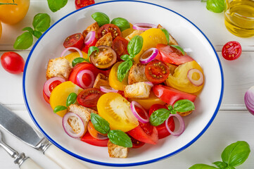 traditional Italian Panzanella salad with tomatoes, onion, fresh basil and bread. Vegetarian dish. top view