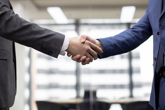 Successful Chinese business people shaking hands in office