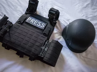 Fototapete Kiew bullet proof vest and helmet for war zone coverage on the bed in hotel in kyiv