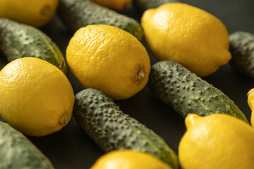 Closeup of lemons and cucumbers. Yellow and green on black background - 622297694