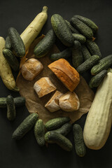 Flat lay with home baked bread and cucumbers on black background - 622298074