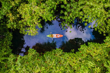 couple in a kayak in the jungle of Krabi Thailand, men and women in a kayak at a tropical jungle in...