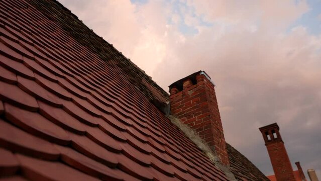 4K close up video with the ceramic red tiled roof of an old house. Tile roof video. Pan camera movement.
