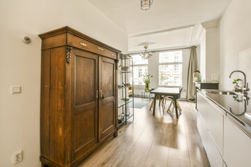 a kitchen and dining area in a small apartment with white walls, hardwood flooring and light wood cabinet doors
