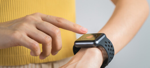 Close up of hand touching smartwatch with heart rate checking app on the screen.