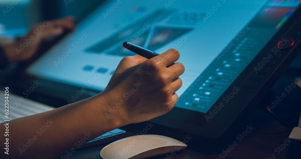 Fototapete Designer working on the table in home studio and hand using digital pen on monitor screen with editor retouching photos.