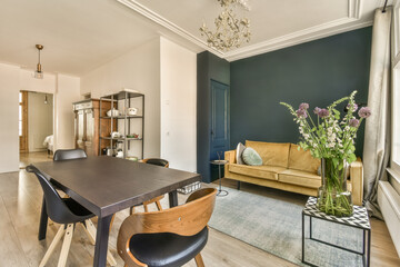 a living room with blue walls and white trim on the ceiling, hardwood flooring in the room is very clean