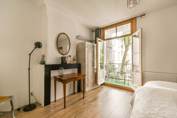 a bedroom with a bed, desk and window looking out onto the garden outside on a sunny day in summer