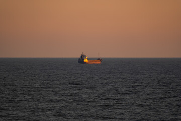 Obraz premium Seascape, a lonely tanker in the Baltic Sea near the coast of Estonia at sunset.