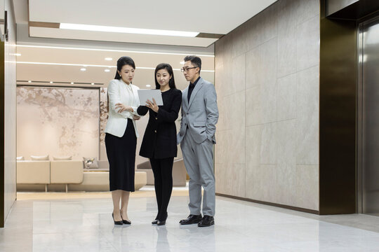 Confident Chinese business people talking in office
