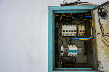 Fototapeta na wymiar Power distribution board. Electrical panel with a row of fuses for different areas in a building, set against a white wall