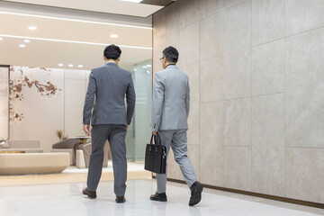 Rear view of Chinese business people walking in office