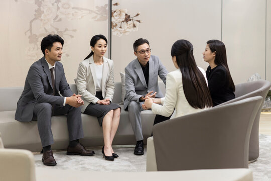 Confident Chinese business people talking in meeting room