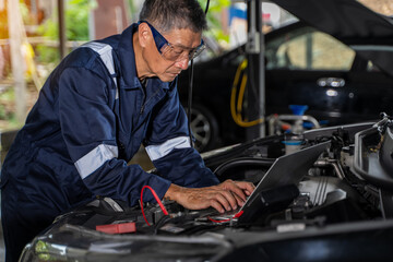 Fototapeta na wymiar Close-up view of auto mechanic using technology working on car engine in garage. Repair service.