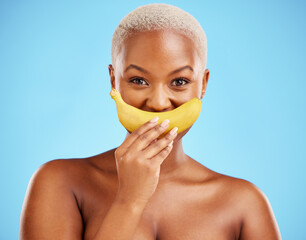 Black woman, banana and mouth for potassium, vitamin or fiber against a blue studio background....