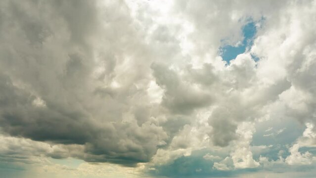 enormous hurricane stormy clouds gettering above blue sky. Low-angle view of storm cloudscape in atmosphere. The astonishing scenery of the sky in the summer season. The rainy weather forecasting.