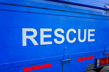 Selective focus on the words "Rescue" on the back of a blue disaster response truck