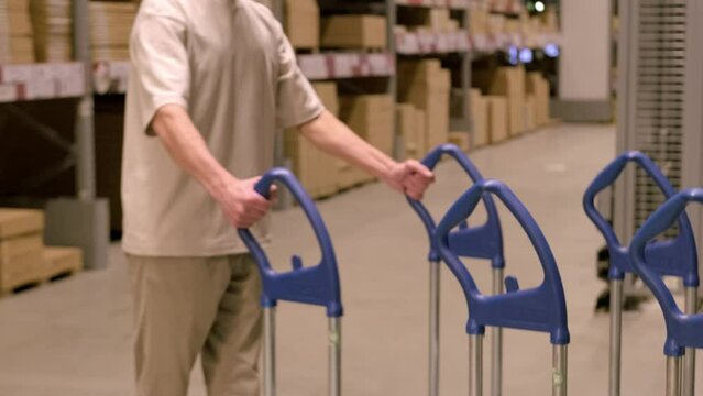 man carries large shopping trolley in IKEA furniture store, shopping for goods DIY and Home Improvement, transport furniture for own projects, Budget-Friendly Shopping, Frankfurt - July 1, 2023