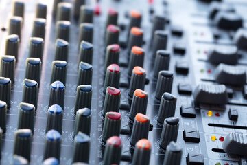 Fototapeta premium Audio mixing console in a streaming, live broadcast, or recording session. Channel faders close up. SIde view. shallow depth of field.