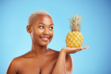 Black woman, pineapple and palm for diet, natural nutrition or health against a blue studio background. African female person smile in happiness holding organic fruit for vitamin, fiber or wellness