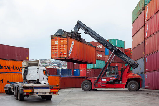 Istanbul, Beylikduzu - Turkey - 07.07.2023 Container yard for Logistic Import Export business, colorful container stack. view from moment of load. crane hold a container and truck wait for load.