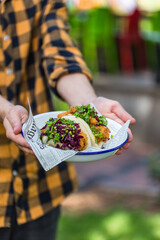 close up of a person holding a plate with thai dish