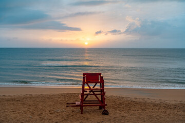Empty lifeguard chairs at Ormond beach during sunrise