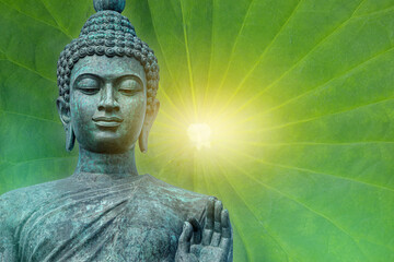 Buddha face isolated on natural green background, big bronze Buddha statue