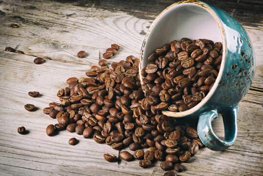 fresh roasted coffee beans in a cup on wooden table