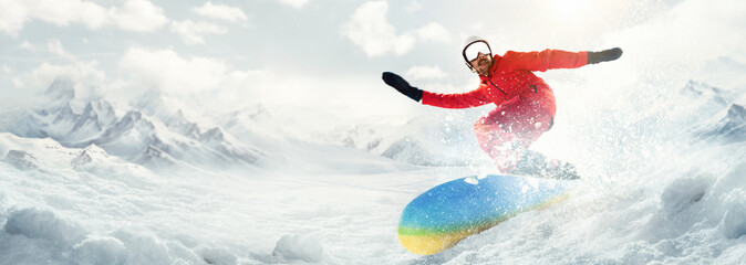Young man, lover of active vacation and lifestyle, riding on snowboard around snowy mountains...