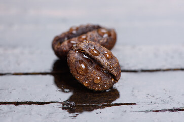 macro of coffee beans on wet wooden background