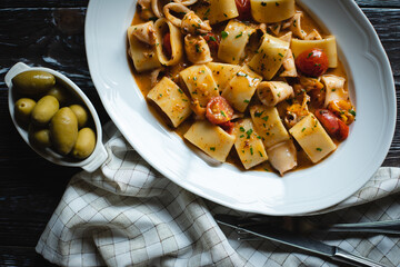 Appetizing Italian pasta with cheese on a dark wooden background