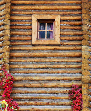 Russian rustic wooden house of logs with a window