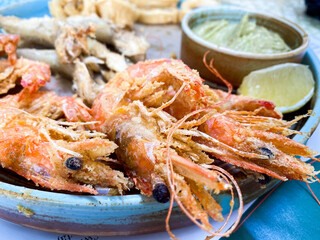 Big Shrimps roasted on pan with lemon and garlic on dark rustic background. top view.