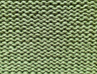Texture of green knitted woolen fabric for wallpaper and an abstract background