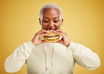 Burger, eating and woman or happy student on a studio, yellow background for restaurant promotion...