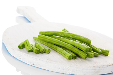 Green beans with water drops on wooden chopping board isolated on white background. Healthy eating.