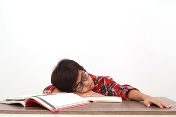 Tired asian student lying down on the desk while studying. Isolated on white