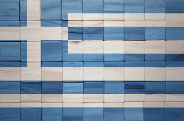 colorful painted big national flag of greece on a wooden cubes texture.