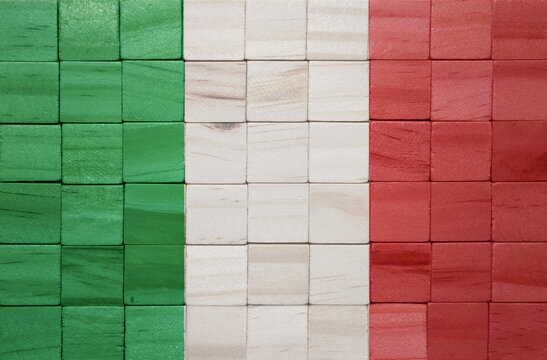colorful painted big national flag of italy on a wooden cubes texture.