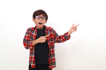 Wow shocked expression of asian boy standing while pointing beside him. Isolated on white