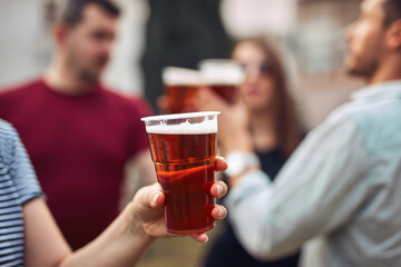 Group of friends enjoying cold beer at a backyard party.