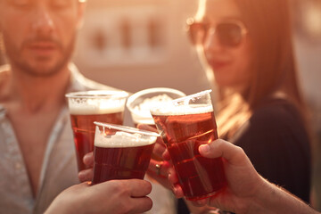 Group of friends enjoying cold beer at a backyard party.