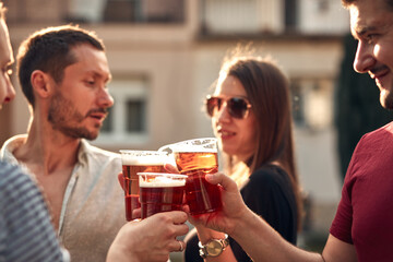 Group of friends enjoying cold beer at a backyard party.